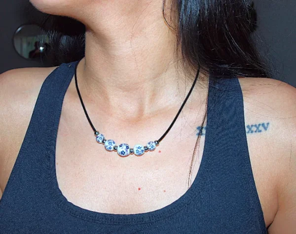 Collar floral de cerámica hecho a mano con detalles en cuero auténtico y acero inoxidable